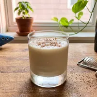 My Hero's Rest — creamy Lon Lon Milk with freshly grated nutmeg, the blue ocarina at the edge of the frame