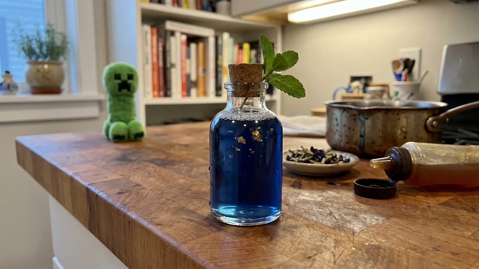 My Caver's Draught — deep indigo flask with gold flakes, a Creeper plush set back at the far edge