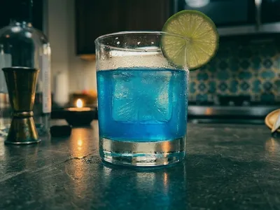 My Contraband Blue — vivid electric blue Romulan Ale on a single ice cube, Starfleet combadge at the edge